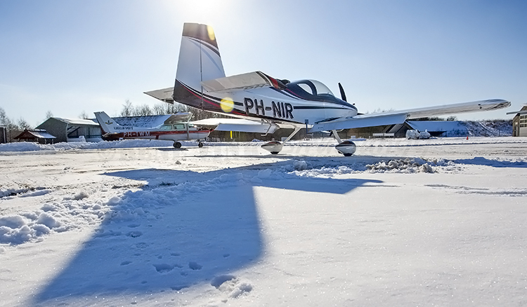 General Aviation Van's and Cessna light aircraft in winter snow at Twente Airport.